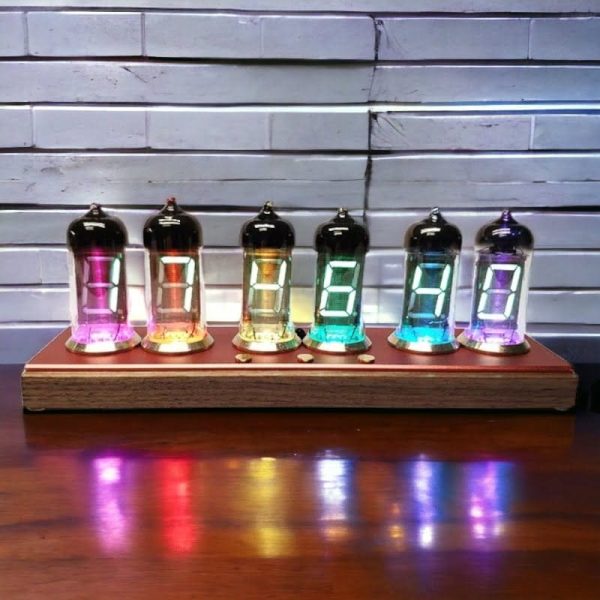 Seis tubos de vidro Nixie com números iluminados em cores diferentes, colocados numa base de madeira, com reflexo colorido na superfície.