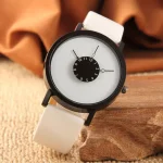 Relógio com mostrador principal branco, ponteiros invertidos e um submostrador circular preto com números de 1 a 12, mostrador de horas e minutos, pulseira branca de couro.