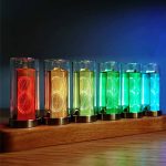 Conjunto de tubos luminosos de diferentes cores, incluindo vermelho, amarelo, verde e azul, com luzes acesas, dispostos numa base de madeira.