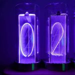 Relógio de tubo luminoso com números 0 e 2, iluminados em luz azul e roxa, com detalhes de LEDs visíveis na estrutura transparente.