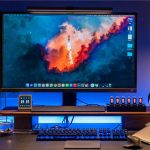 Monitor de computador com fundo de espaço, foguete a lançar-se, e ícones de aplicações na barra lateral direita.