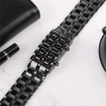 Pulseira de relógio de metal preta com acabamento brilhante, vista de cima, com detalhes das ligações e acabamento polido.