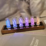 Relógio Nixie com tubos de vidro iluminados em cores diferentes exibindo números de 0 a 9, montado numa base de metal.