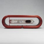 Relógio Nixie com tubo de exibição de números, moldura de madeira ovalada, design vintage e detalhes visíveis do tubo de exibição.