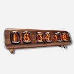 Relógio Nixie vintage com display de tubos de vidro e números laranja brilhantes, montado numa base de madeira escura com pés de suporte.