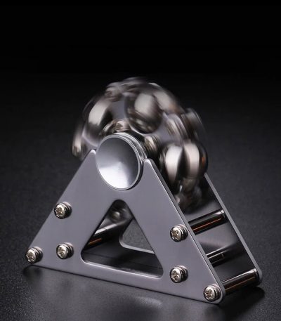 Spinner de mão com bolas metálicas em movimento, destaque para estrutura triangular de metal e bolas de aço brilhantes.