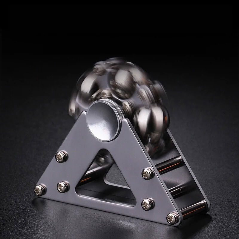 Spinner de mão com bolas metálicas em movimento, destaque para estrutura triangular de metal e bolas de aço brilhantes.