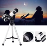 Telescópio com lente grande, suporte ajustável e acessórios, usado por duas crianças ao ar livre à noite observando estrelas e a lua crescente.