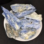 Vários cristais de cianite azul em bruto, com diferentes tamanhos e formas, exibindo a sua cor característica e textura mineral.