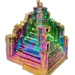 Cristal de Bismuto com estrutura em escadas e cores iridescentes, visto de ângulo frontal, destacando os detalhes e a textura do mineral.