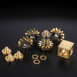 Engrenagens douradas com rolamentos e cubo de metal, componentes de um mecanismo de ciência ou tecnologia.