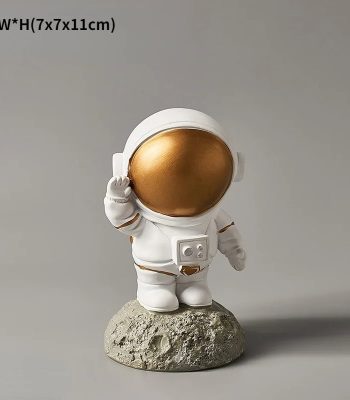 Estatueta de astronauta com capacete dourado, vestuário branco, em pé sobre uma base de rocha, com detalhes de capacete e traje espacial.