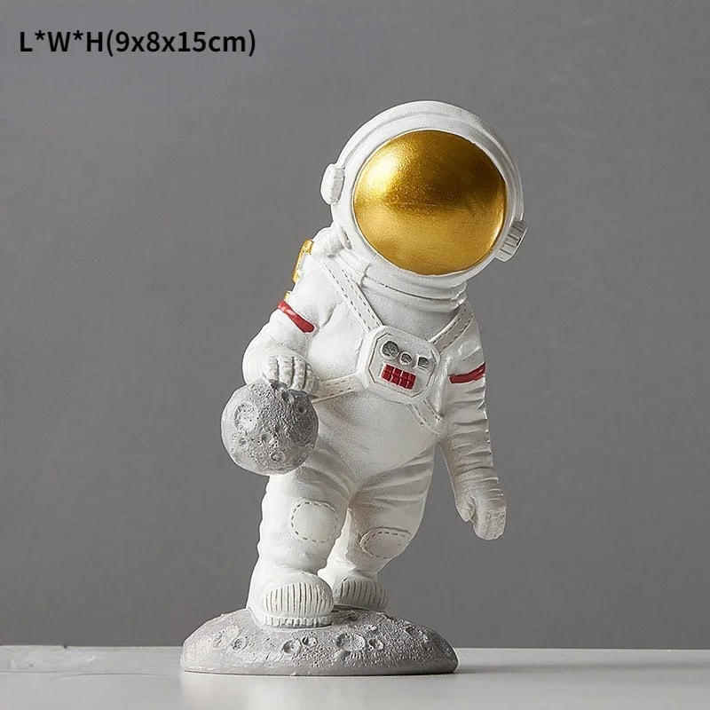 Estatueta de Astronauta com Meteorito Estatueta de astronauta com capacete dourado, segurando um meteorito, em pose de exploração lunar, com detalhes em vermelho na roupa e base de rocha.