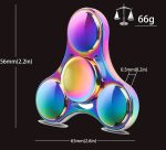 Fidget spinner de metal com acabamento iridescente, dimensões de 65mm por 56mm, peso de 66g, com três braços e detalhes de medição.