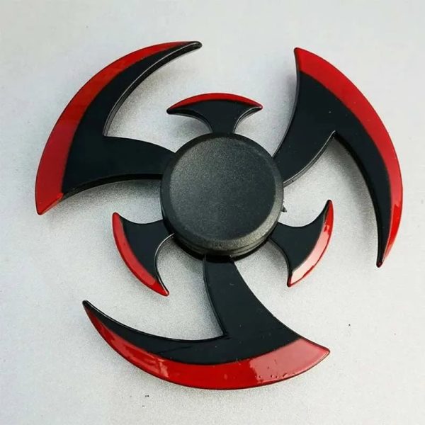 Fidget spinner com design de shuriken, preto e vermelho, com várias lâminas curvas e pontiagudas, em superfície plana.
