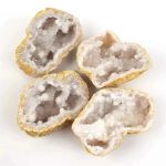 Quatro pedaços de geodo de cristal de rocha com interior cristalino branco e exterior áspero.