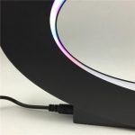 Globo terrestre magnético com iluminação LED colorida, flutuando sobre base magnética, visto de lado com foco na iluminação e na base.