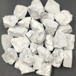 Pedras de howlite bruta com superfície branca e veios cinzentos, várias formas irregulares, usadas em decoração ou coleções de minerais.
