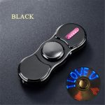Fidget spinner preto com luz LED rosa e luz de leitura azul, visto de cima, sobre fundo escuro.