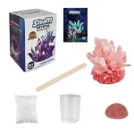 Conjunto de materiais para cultivo de cristais, incluindo embalagem, cristais rosa, copo, pau de madeira e pó cristalino.