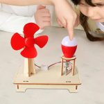 Criança a interagir com um gerador eólico de brinquedo e uma lâmpada LED, demonstrando energia renovável e eletricidade.