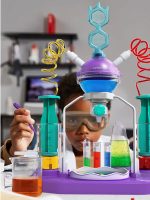 Criança com óculos de proteção manipula tubos de ensaio coloridos e equipamento de laboratório de plástico.
