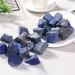 Pedras de lápis-lazúli brutas de diferentes tamanhos e formas, com tons de azul intenso e detalhes minerais visíveis.