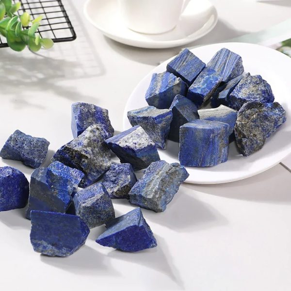 Pedras de lápis-lazúli brutas de diferentes tamanhos e formas, com tons de azul intenso e detalhes minerais visíveis.
