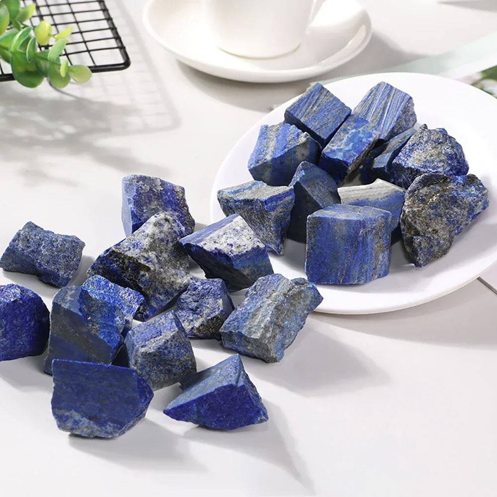Pedras de lápis-lazúli brutas de diferentes tamanhos e formas, com tons de azul intenso e detalhes minerais visíveis.