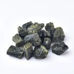 Várias pedras de turmalina verde com superfícies brilhantes e texturadas, exibidas sobre fundo branco, mostrando detalhes de suas cores e formas.