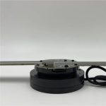 Dispositivo de projeção holográfica com base circular preta e braço metálico ajustável, ligado a um cabo de energia, usado para criar hologramas tridimensionais.