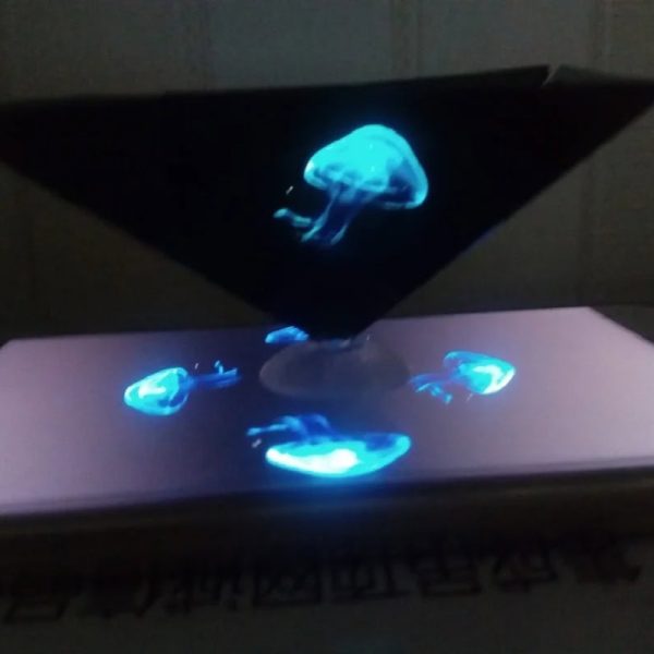 Holograma de uma medusa azul projetada em um dispositivo com luzes brilhantes e efeito de água, visto de cima.
