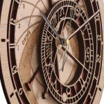 Relógio astronómico de madeira com detalhes em preto e dourado, mostrando fases lunares e posições planetárias, com ponteiros finos e numerais romanos.