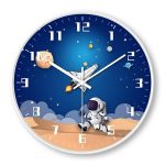 Relógio de parede com tema espacial, astronauta, planetas, estrelas e nave espacial, com fundo azul escuro e detalhes coloridos.