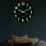 Relógio de parede com números luminosos verdes, mostrando a hora 10:10, em uma sala com decoração moderna e confortável.