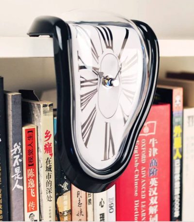 Relógio de parede com efeito de derretimento, estilo surrealista, pendurado numa estante de livros com títulos em chinês e inglês.