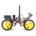 Robô com rodas amarelas, antena, circuito elétrico visível e câmara na parte frontal, usado para projetos de robótica educativa.