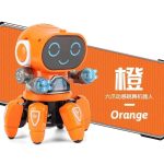 Robô de cor laranja com rosto digital sorridente, braços transparentes com luz azul, e pernas articuladas, em frente a uma caixa com o nome "Orange".