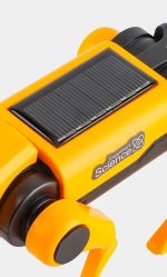 Robô de plástico amarelo e preto com painel solar na parte superior, rodas e braços articulados, destinado a atividades educativas de ciência para crianças.