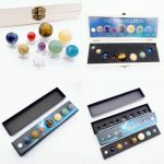 Conjunto de oito planetas em miniatura feitos de pedras preciosas, exibidos em caixas de apresentação com fundo branco.