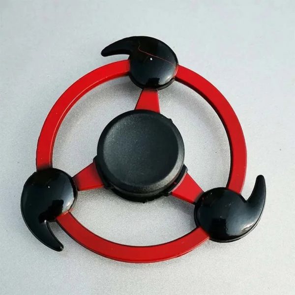 Spinner de mão com design inspirado no Sharingan, com três garras pretas e uma estrutura vermelha circular, usado para entretenimento e alívio de stress.