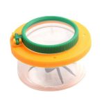 Lupa de mão com lente grande, moldura verde e tampa amarela, usada para observar insetos de perto.