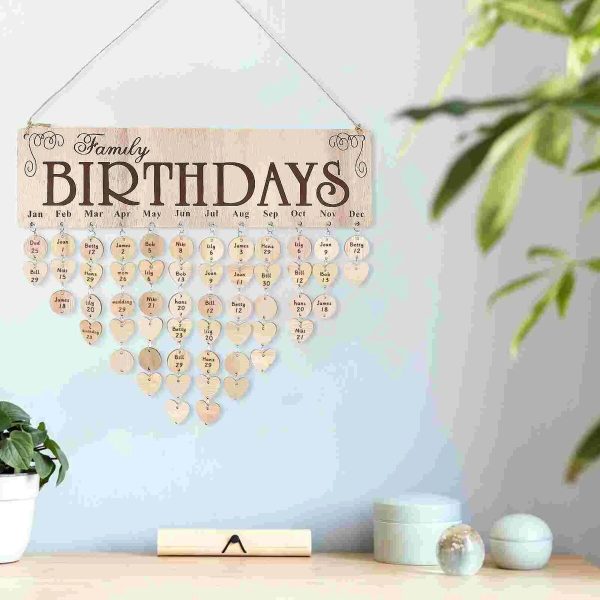 Quadro decorativo com dias do ano em forma de corações, para marcar aniversários familiares, pendurado na parede com uma corda.