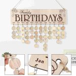 Calendário de aniversários de madeira com pendurais em forma de coração e meses do ano em letras grandes.