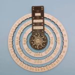 Calendário perpétuo de parede com disco de madeira, mostrando o mês, dia e data, decorado com símbolo do sol e lua, em tons naturais.