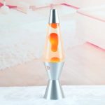Lâmpada de lava com base metálica prateada e tubo de vidro com lava laranja a derreter-se lentamente.