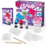 Conjunto de ingredientes e moldes para fazer sabão com cores e aromas, incluindo moldes, corantes, e utensílios de madeira.