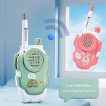 Intercomunicador de brinquedo com antena, alto-falante e decoração de tartaruga e coelho, em cores verde e rosa, com alcance de até 300 metros.