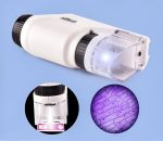 Microscópio portátil com lente de ampliação, luz LED e amostra de tecido vegetal sob o microscópio.