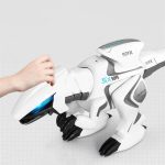 Robô dinossauro branco com detalhes azuis, com uma mão humana a tocar-lhe a cabeça, em fundo branco.